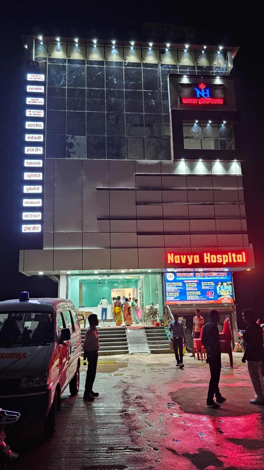 Navya Hospital illuminated at night with ambulance ready